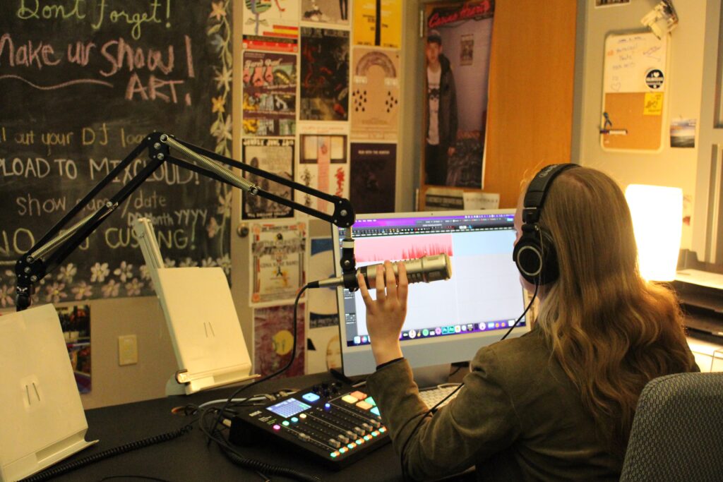 Sophie Duvall sits at her desk while recording her weekly radio show