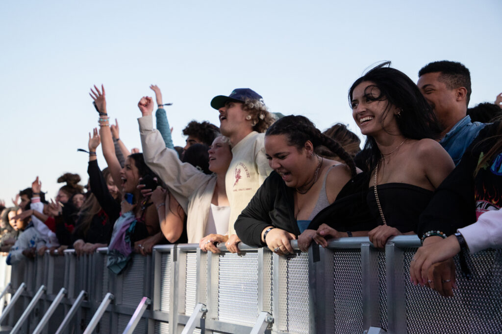 A crowd of students lean over the concert gate at the Biggest Little Festival.