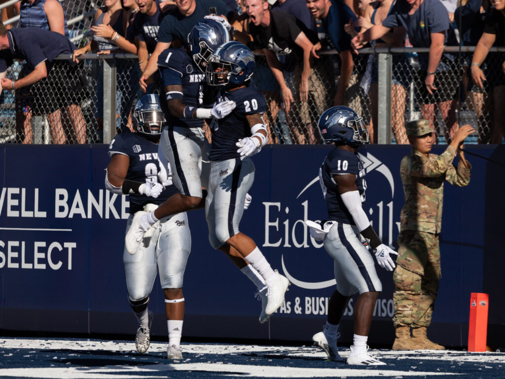 Two Nevada football players jump in celebration