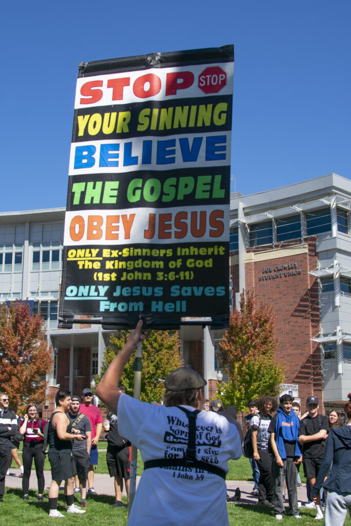 Daniel John Lee holds up a sign that says "Stop your sinning. Believe the Gospel and Obey Jesus" in front of students at the Joe Crowley Student Union on UNR campus.