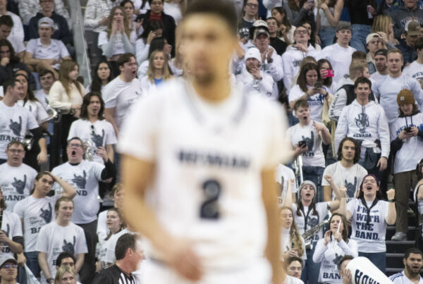 A basketball player out of focus with a crowd behind them
