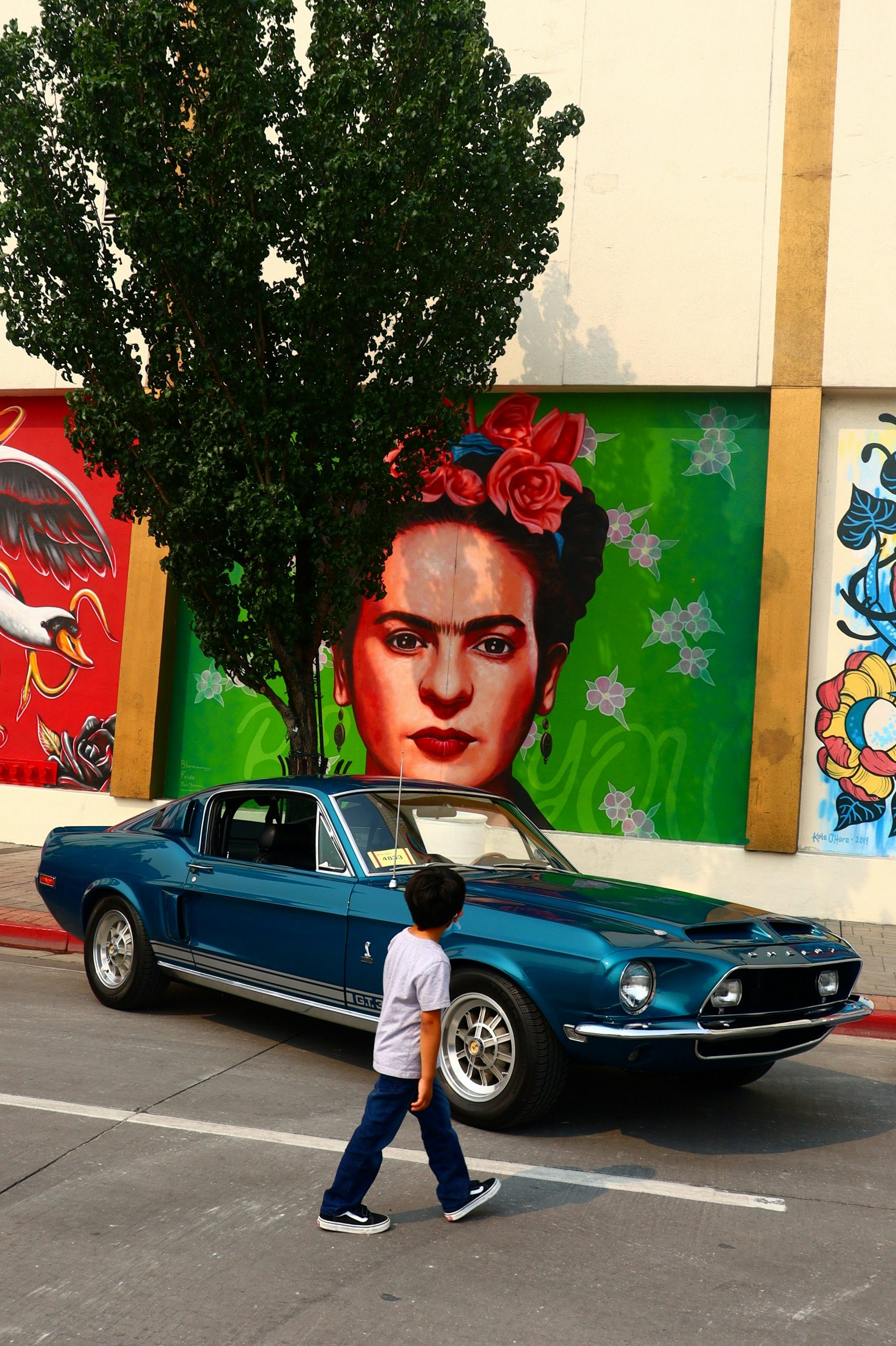 Child looking at a mural of Frida Khalo