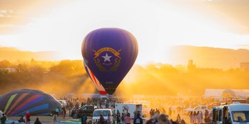 The famous Battle Born balloon, piloted by Pat Irwin, idles on the field in front of the rising sun during the Great Reno Balloon Race on Thursday, Sept. 10.