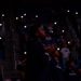 Vaugn Weems looks out into the court and the lights are off and the audience holds their phone lights up.