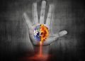 An image of a hand reaching up towards a burning Earth.