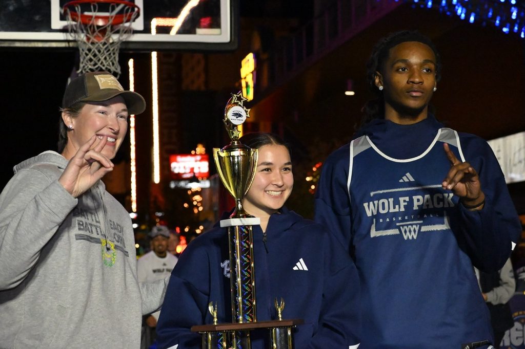 Alumni Marissa Hammond, junior guard Sierra Chambers, and senior guard Keyon Kensie Jr. get presented with the Wolf Pack Shootout trophy.
