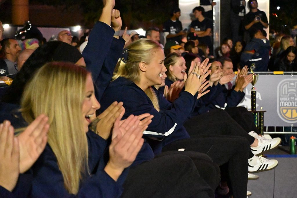 The women’s basketball team cheering on teammate junior guard Aili Tanke in the 3-point contest.