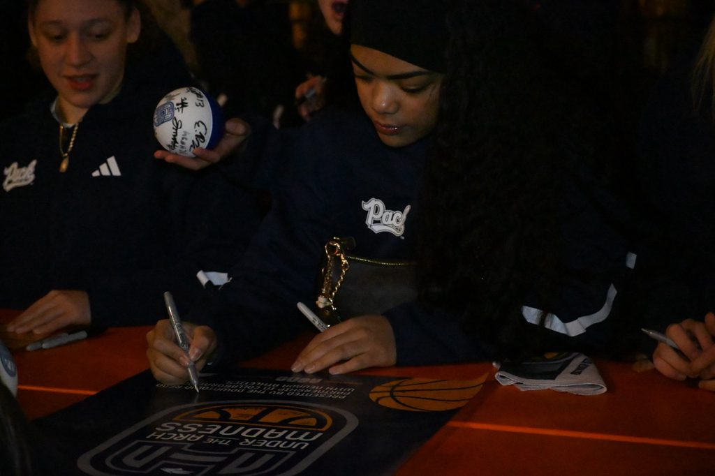 Freshman guard Taua Puloka signs a poster.