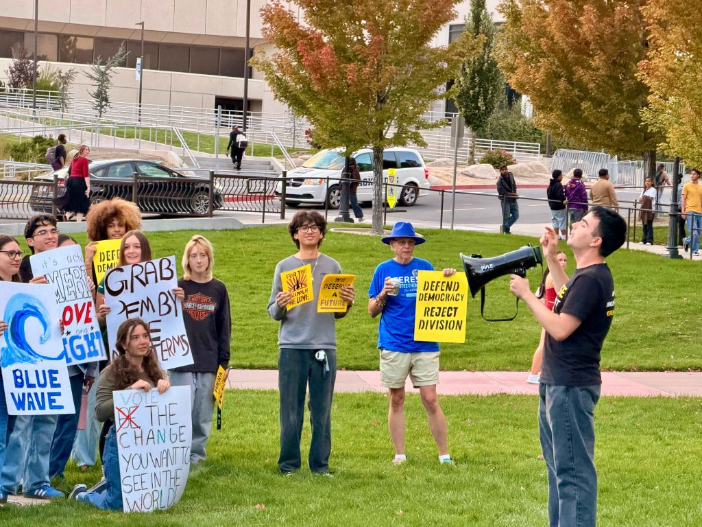 Michael Keyes speaking in front of protesters outside the JCSU, holding a megaphone.