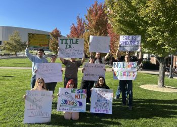 Students and community members holding up their signs at the Joe Crowley Student Union plaza before the protest began on Thursday, Oct. 8.