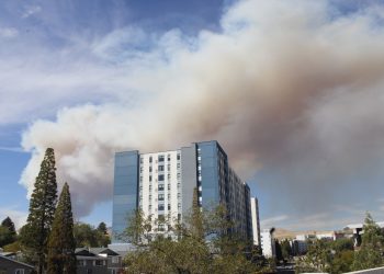 Smoke looms over a student apartment building.