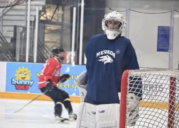 Nevada men's hockey goalie looks to the sidelines as the team warms up.