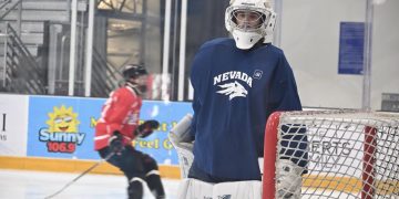 Nevada men's hockey goalie looks to the sidelines as the team warms up.