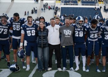 University of Nevada, Reno president Brian Sandoval, along side the University's first lady Lauralyn Sandoval and Nevada football head coach Jeff Choate celebrate the win along side players, cheerleaders and mascots on Saturday, Oct. 24 at Mackay Stadium.