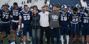 University of Nevada, Reno president Brian Sandoval, along side the University's first lady Lauralyn Sandoval and Nevada football head coach Jeff Choate celebrate the win along side players, cheerleaders and mascots on Saturday, Oct. 24 at Mackay Stadium.